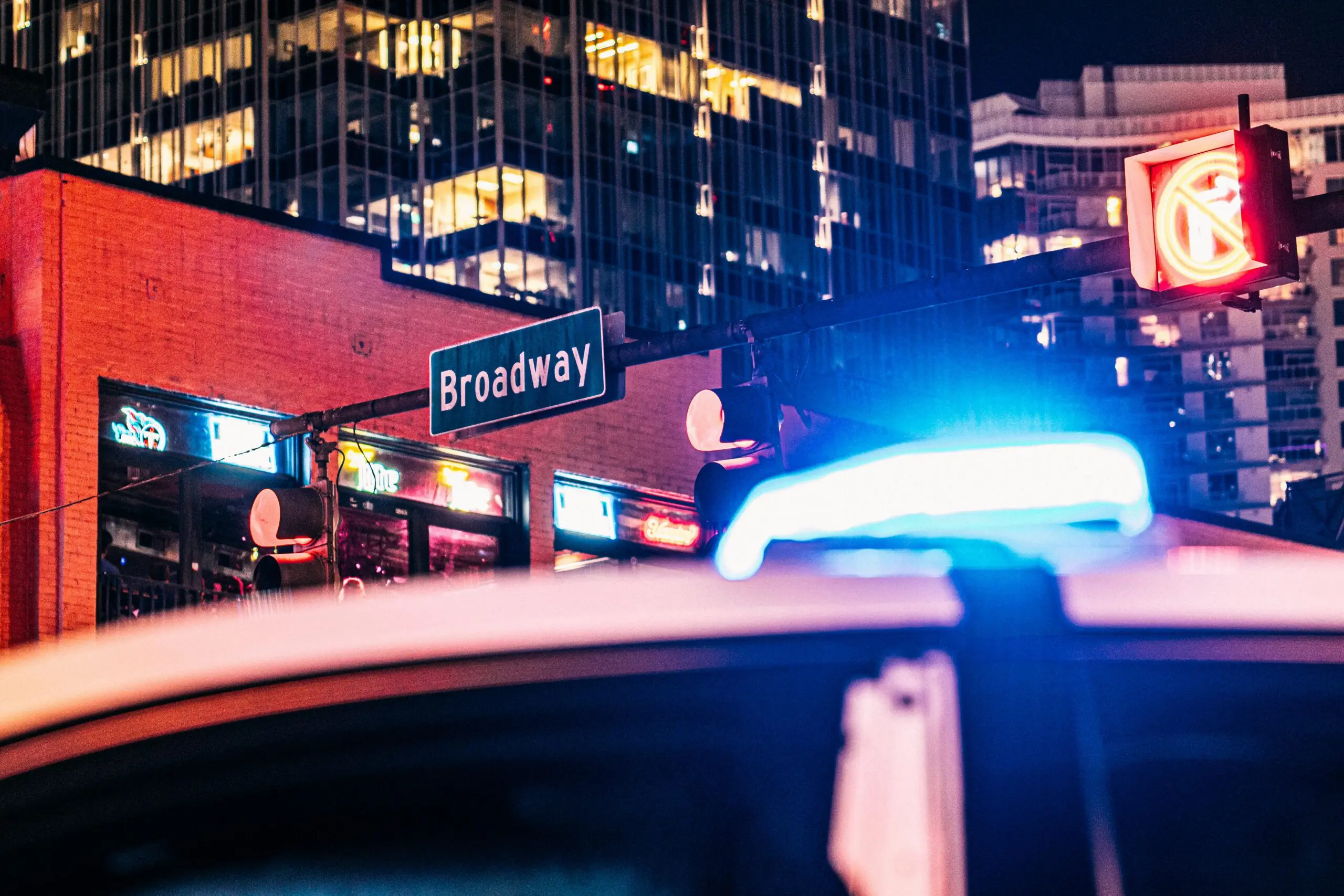 Police car with a blue light on top, parked on the street, indicating an active response or emergency situation.