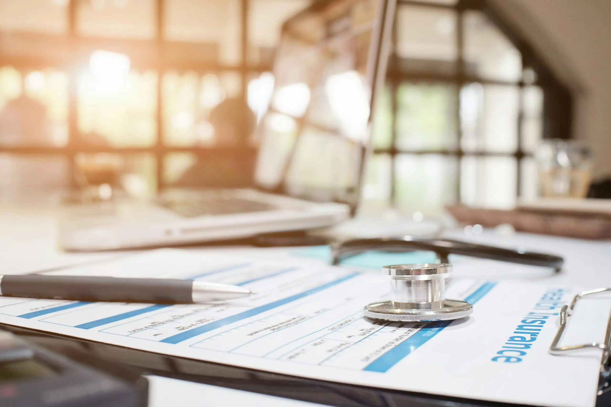 A stethoscope rests on a medical document on a desk, symbolizing healthcare and patient assessment.