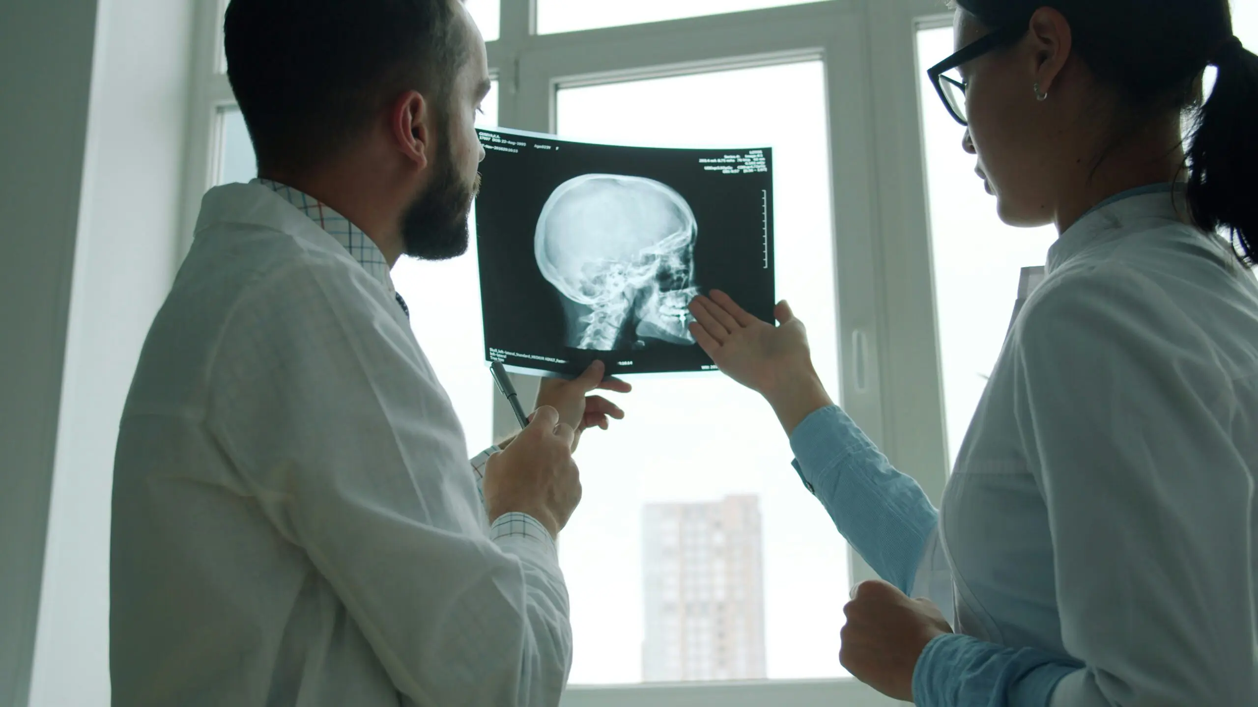A man and woman examining an X-ray image together, discussing its details and implications.