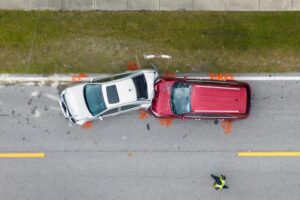 Overhead view of a damaged car after a collision, showing significant impact on the driver's side.