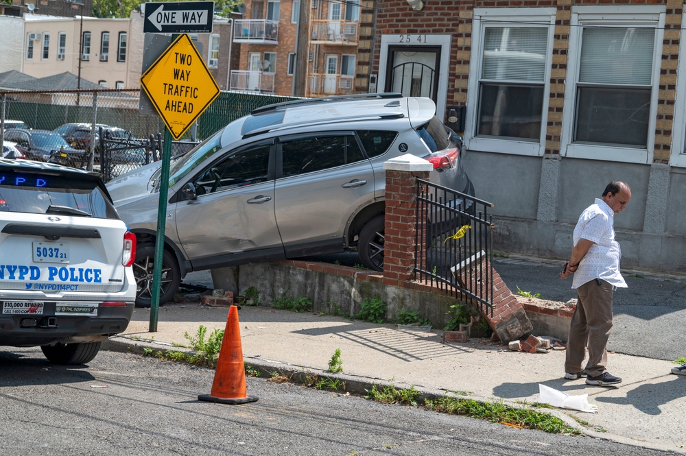 Police at the scene of a car crash into a residential fence in New York